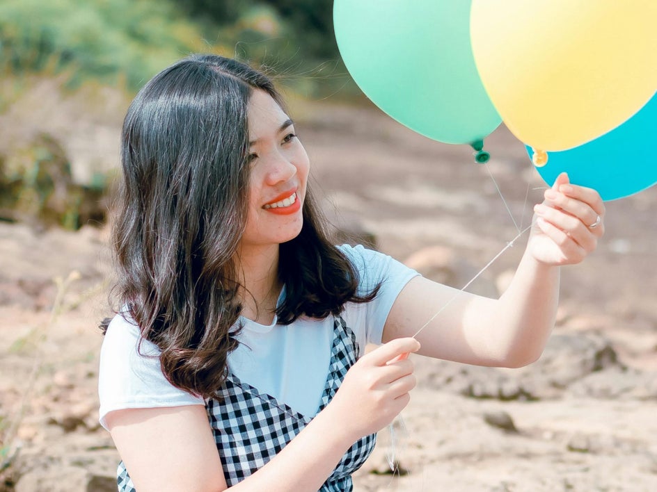 woman with balloons smiling