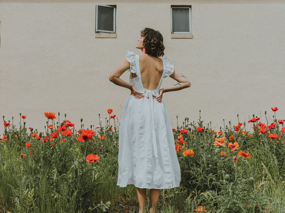 woman in white dress around flowers