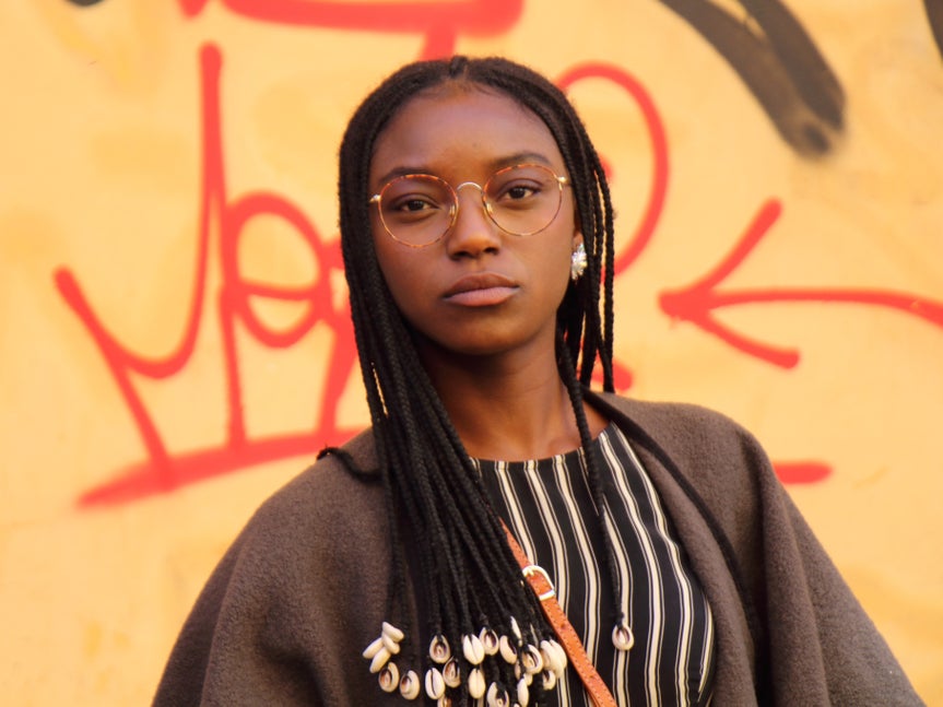 girl in front of a graffitied wall